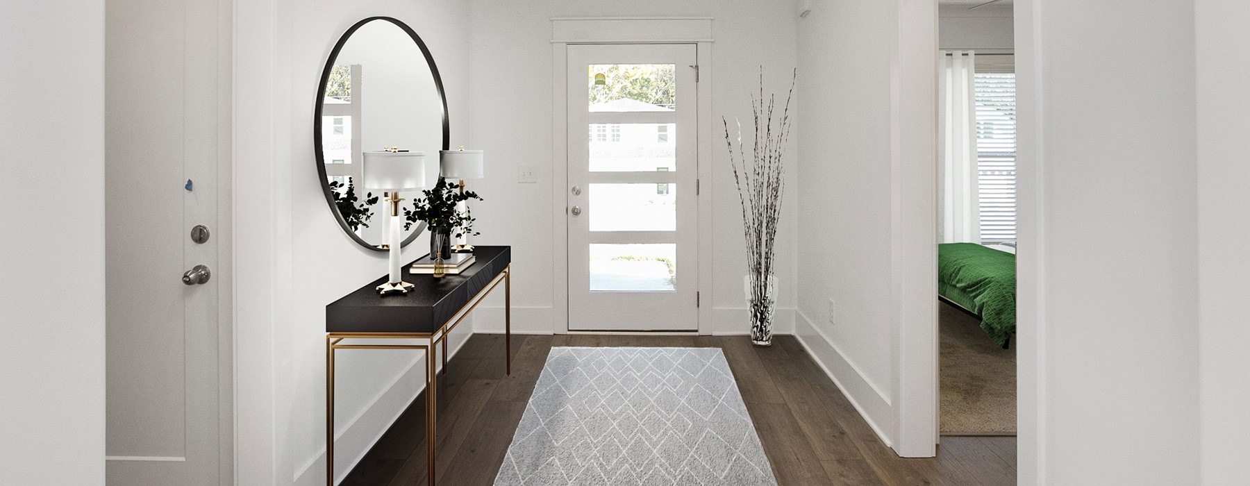 Large well lit foyer with wood floors 